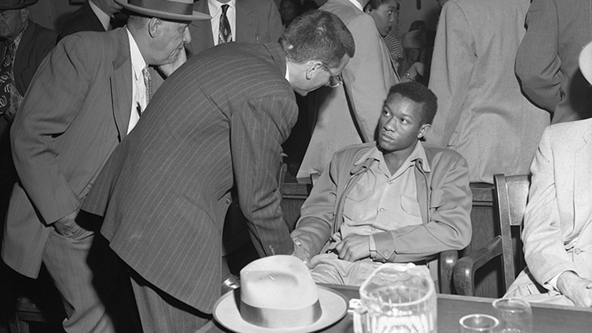 Tommy Lee Walker talks to a man during his trial