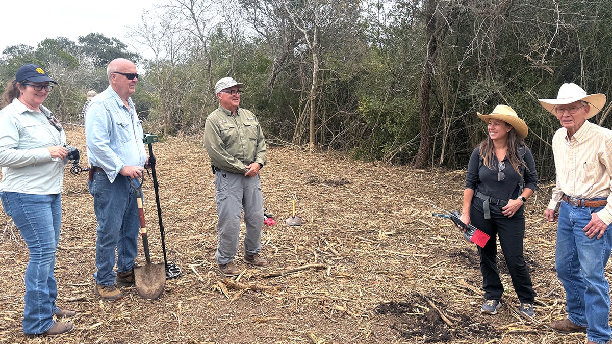 Excavators in cowboy hats standing at site