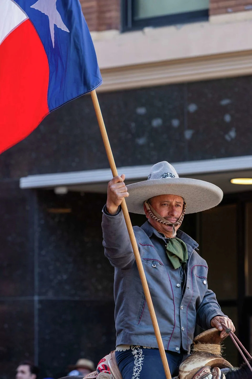 A charro rider holds the Texas flag during the Western Heritage Parade on Saturday, Feb. 7, 2026. (Blaine Young/Contributor)