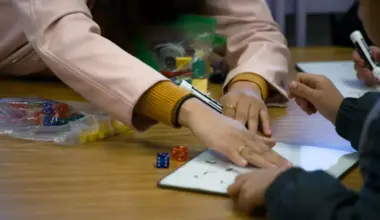 A Rufino Mendoza Elementary teacher uses her hand to wipe a dry-erase board after a student answered a math question on Jan. 20, 2024.