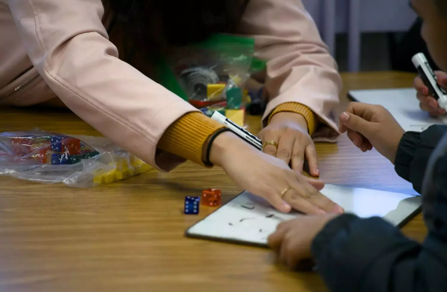 A Rufino Mendoza Elementary teacher uses her hand to wipe a dry-erase board after a student answered a math question on Jan. 20, 2024.