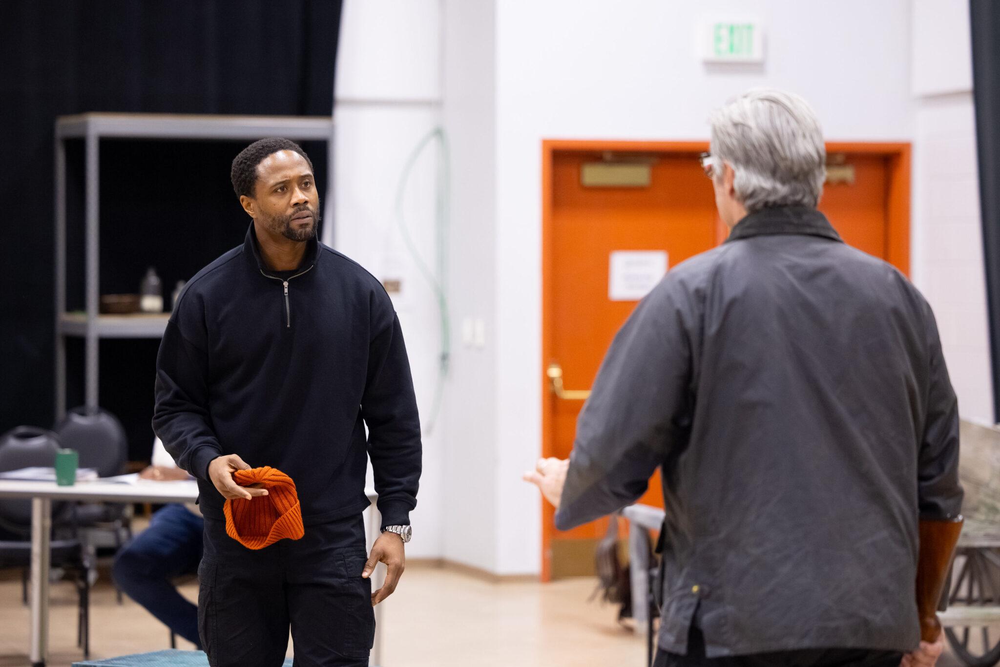 Two men stand opposite menacingly.