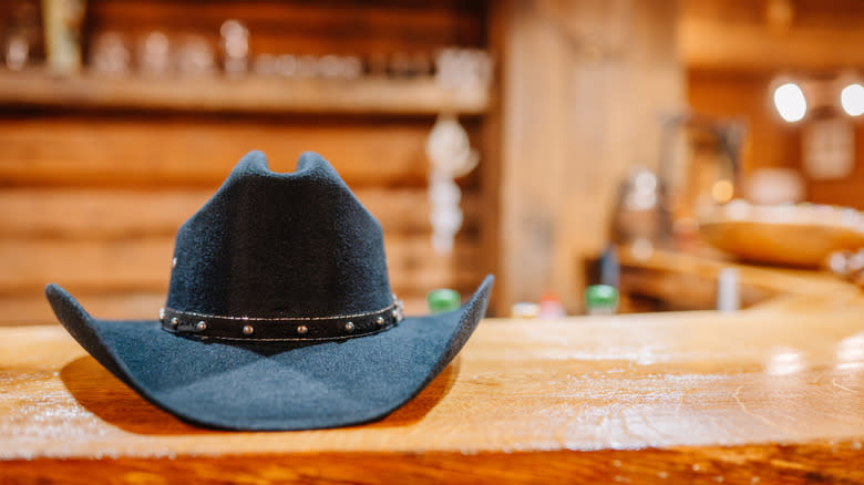 Black cowboy hat on wood countertop