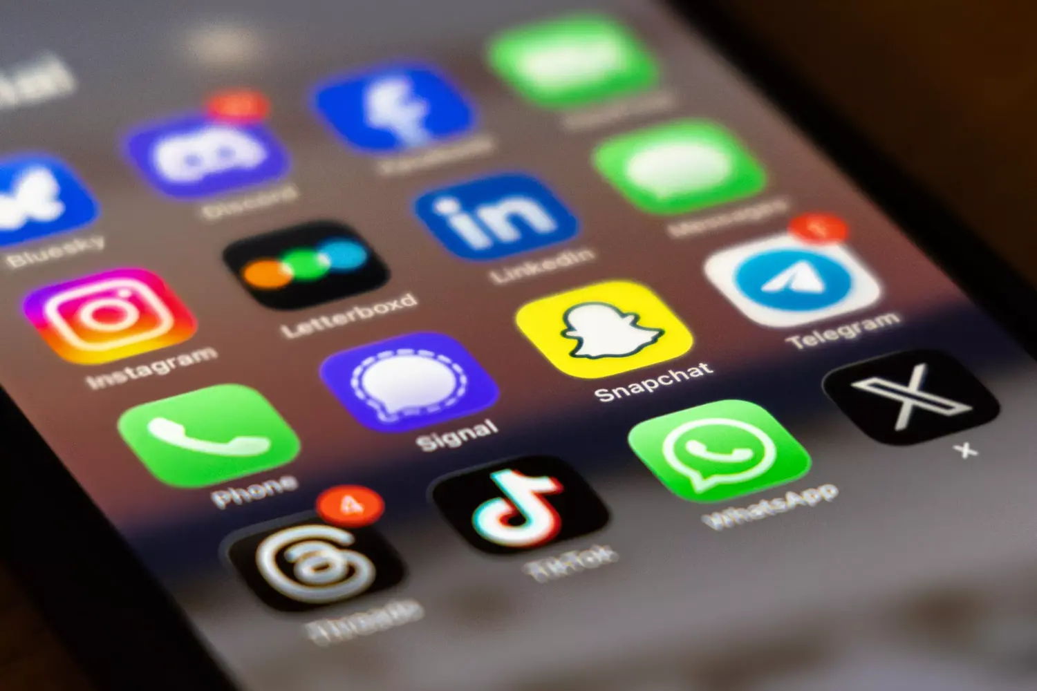 The Snapchat app icon is displayed among other social media apps on a smartphone screen.