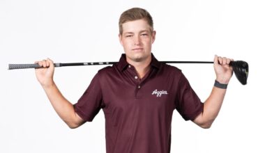Aaron Pounds poses arms folded in front of a Lone Star Flag themed Texas A&M backdrop
