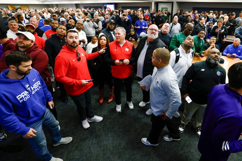 Lovejoy's Todd Dodge (center) and other high school football coaches and staff from across...