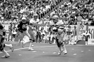 Roger Staubach (12), Dallas Cowboys quarterback, hands off to runner Scott Laidlaw (35)...