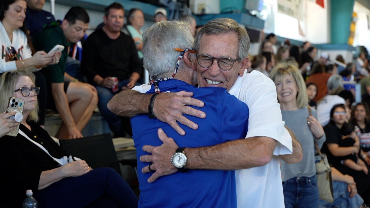 King 1974 diver hugs his former coach Trey Collins at the 2026 Region meet