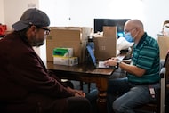 Nicholas Rutsis, left, speaks with caseworker with Wellness Center for Older Adults, Lee...