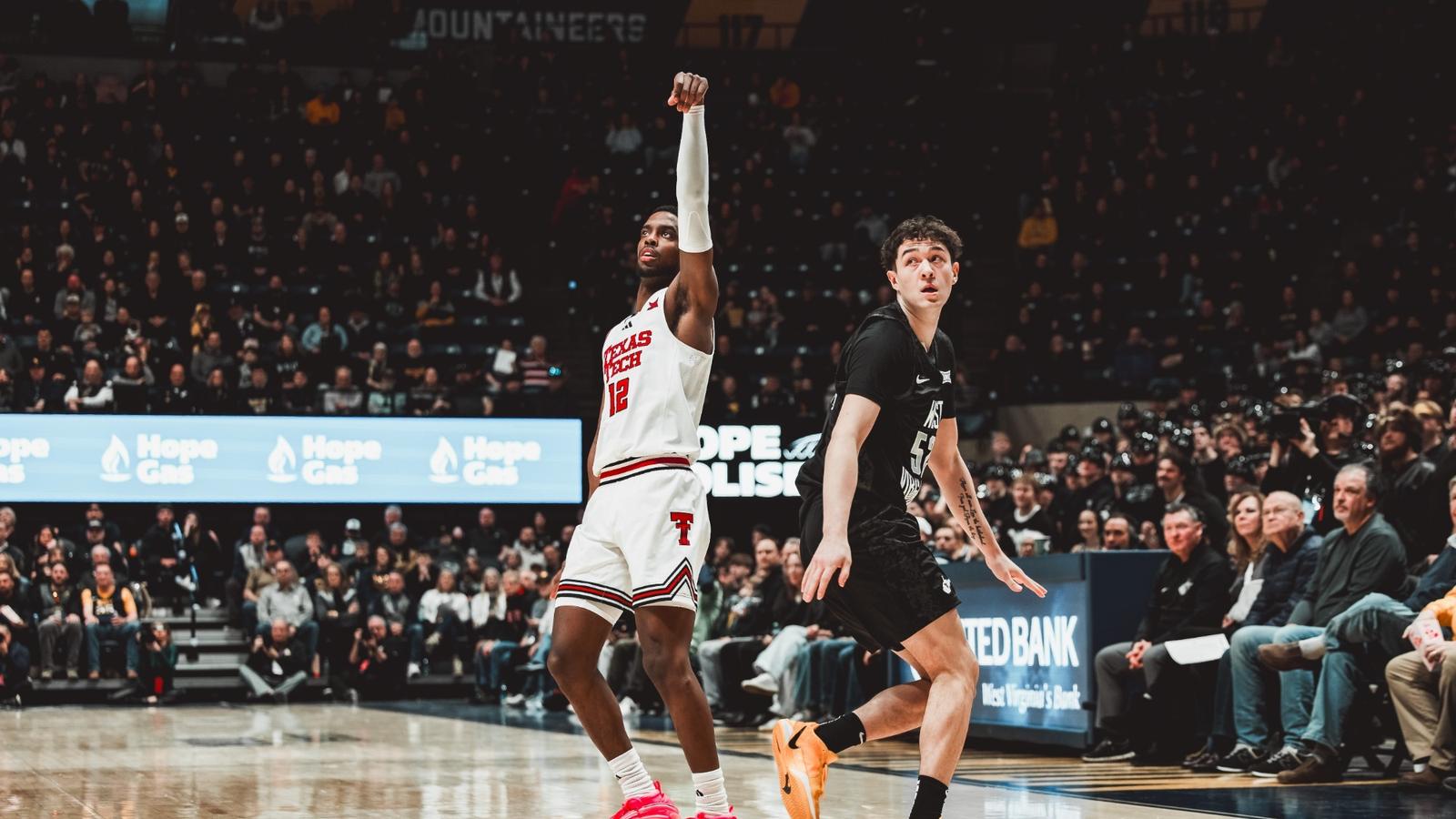 Christian Anderson launches a 3-pointer over the outstretched arm of a West Virginia defender.