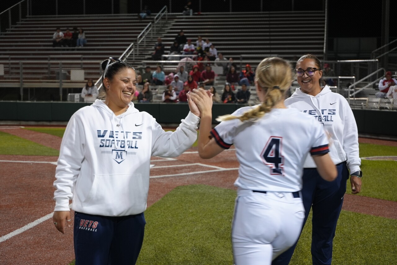 Veterans Memorial softball coaches high five starting pitcher Lyla Creek