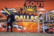 Artist Theo Ponchaveli paints a new mural depicting the words “Welcome to Sunny South...
