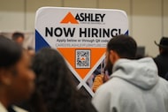 A sign with information about employment is displayed during a job fair in Dallas, Jan. 14,...