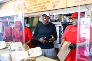Owner Walter Williams (center) laughs behind the line as workers prepare food for customers...
