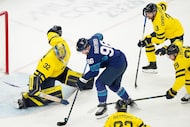 Finland's Mikko Rantanen, center, tries to score past Sweden's goalkeeper Filip Gustavsson...