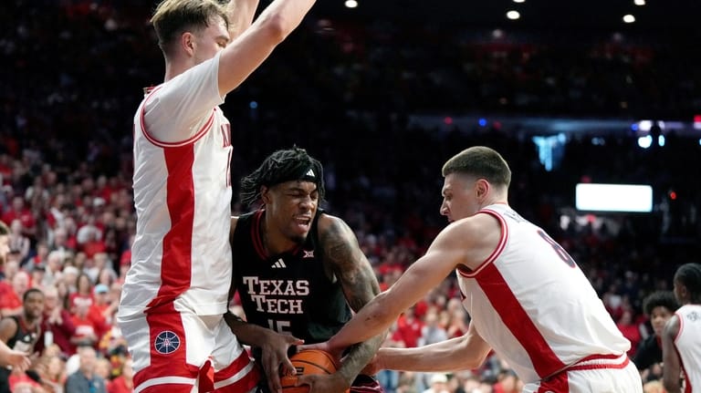 Texas Tech forward JT Toppin drives between Arizona center Motiejus...