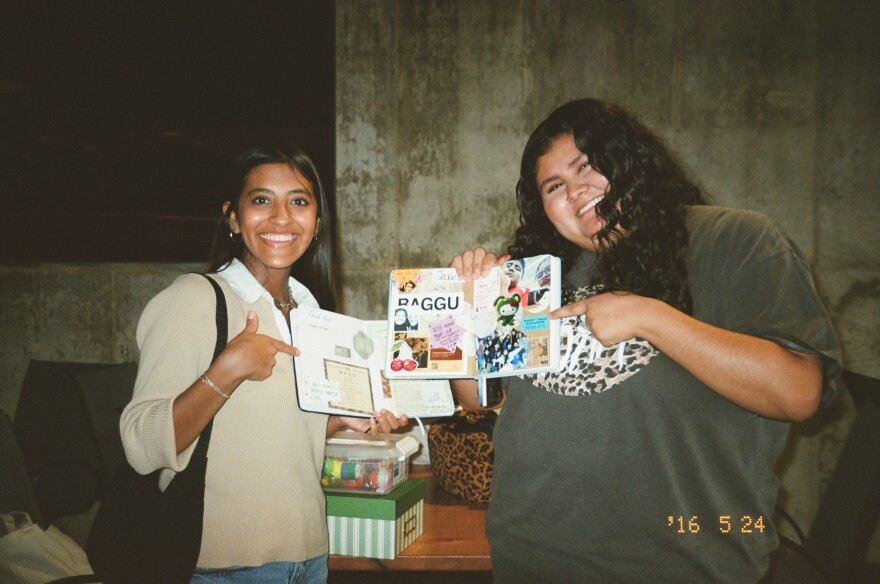 A film photo of two young women showing off their journals.