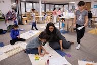 Curiosity Studio guide Shahnaz Lakhani (seated center right) works with students during core...