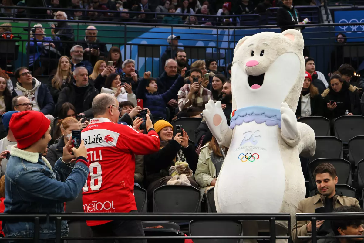 Olympic mascot Tina poses with fans at the hockey arena. She has a favorite song to dance to.