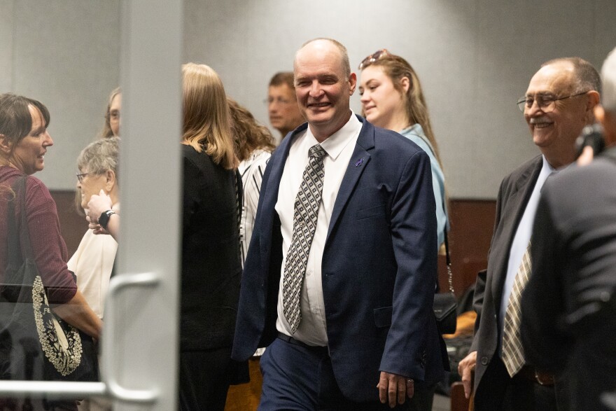 A man leaves a room through a doorway. 