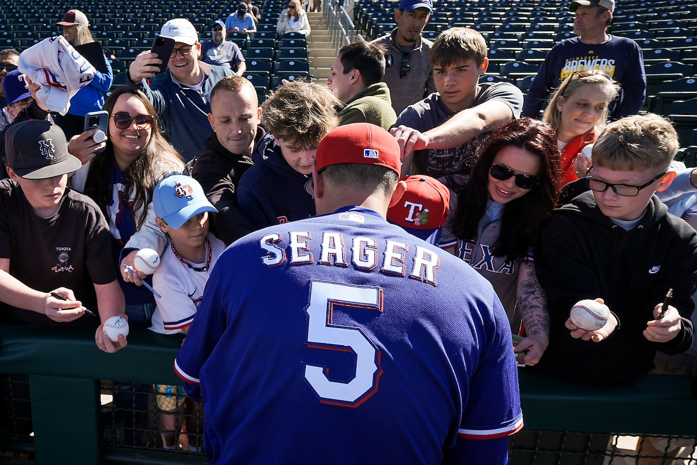 Texas Rangers shortstop Corey Seager signs autographs before a spring training game against...