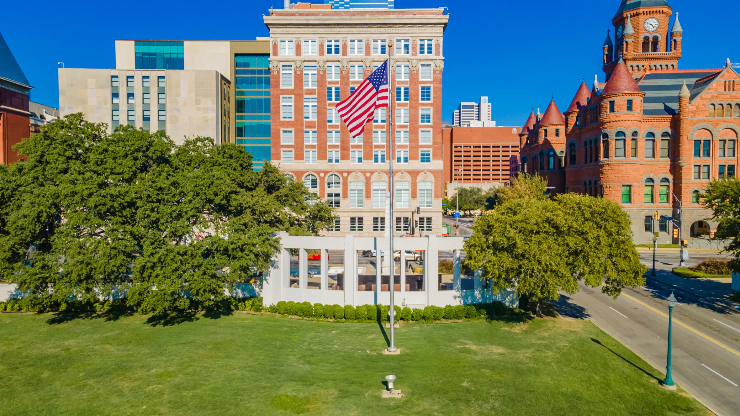 The Sixth Floor Museum building with an American flag and the Old Red Museum of Dallas County.