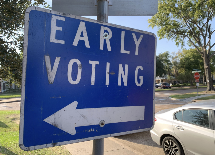 A blue sign reads "early voting" with an arrow pointing to the left. 