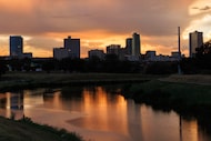 The sun sets behind the downtown Fort Worth skyline and Trinity River after thunderstorms...
