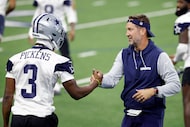 Dallas Cowboys head coach Brian Schottenheimer helps wide receiver George Pickens (3) to his...