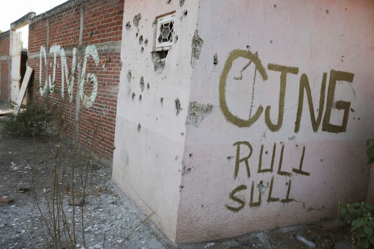 A bullet-riddled facade with the acronym of the Jalisco New Generation Cartel (CJNG) is pictured in El Aguaje after the visit of Vatican's ambassador to Mexico Franco Coppola to the area and to the municipality of Aguililla, an area where the Jalisco New Generation Cartel (CJNG) and local drug gangs are fighting to control the territory, in Michoacan state, Mexico April 23, 2021. REUTERS/Alan Ortega