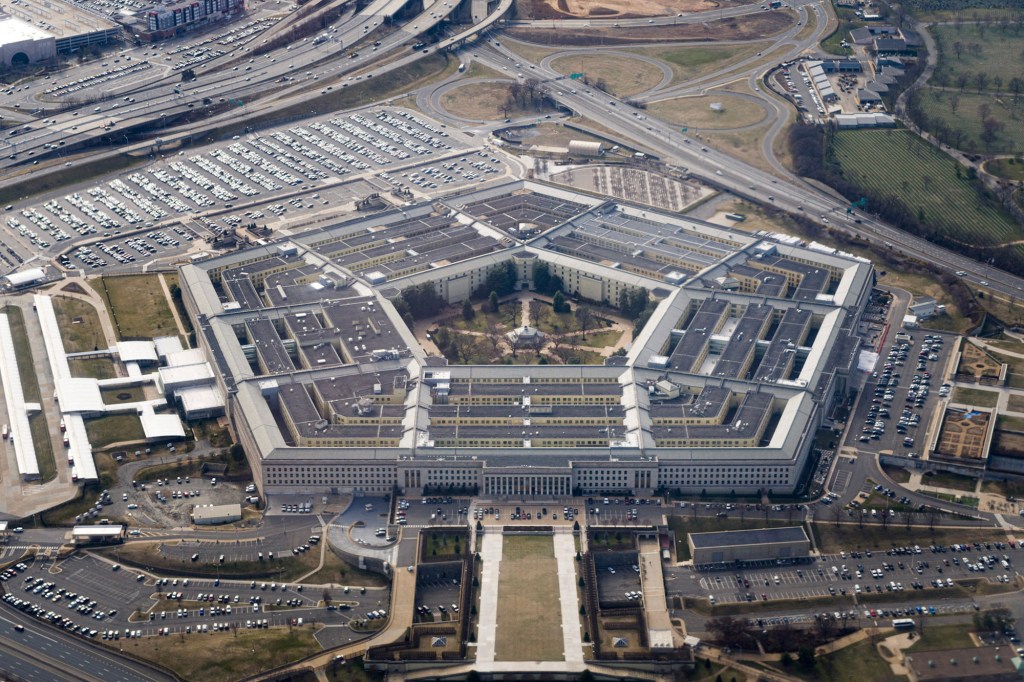 Aerial view of the Pentagon in Arlington, Virginia, showing the pentagonal building, surrounding parking lots, and nearby highways.