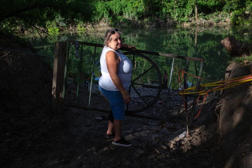 Sara Dubose stands near the Guadalupe River on her land in Gonzales County on July 30, 2025. Credit: Dylan Baddour/Inside Climate News