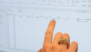 a finger pointing to a line on a spreadsheet
