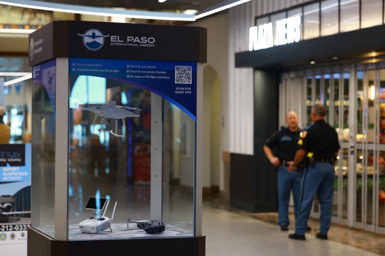 Police officers stand near an exhibition of U.S. Federal Aviation Administration (FAA) drones, at El Paso International Airport