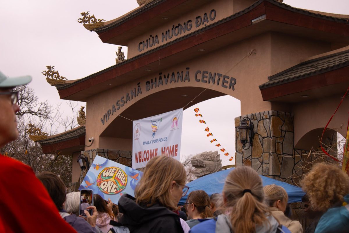 Followers hold up signs and follow the monks into their monastery to hear them speak. 