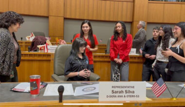 Representative Sarah Silvia (D-Do&ntilde;a Ana & Otero) visits with students from Gadsden Independent School District while Emily Smolik, a sophomore at Chaparral High School, sits in her seat on the House floor.