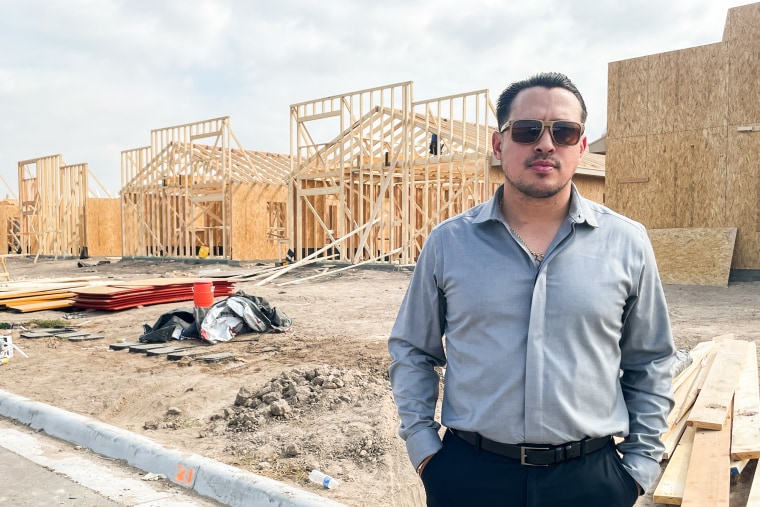 Mario Guerrero, executive director of the South Texas Builders Alliance and owner of a home building company stands in front of a construction site.