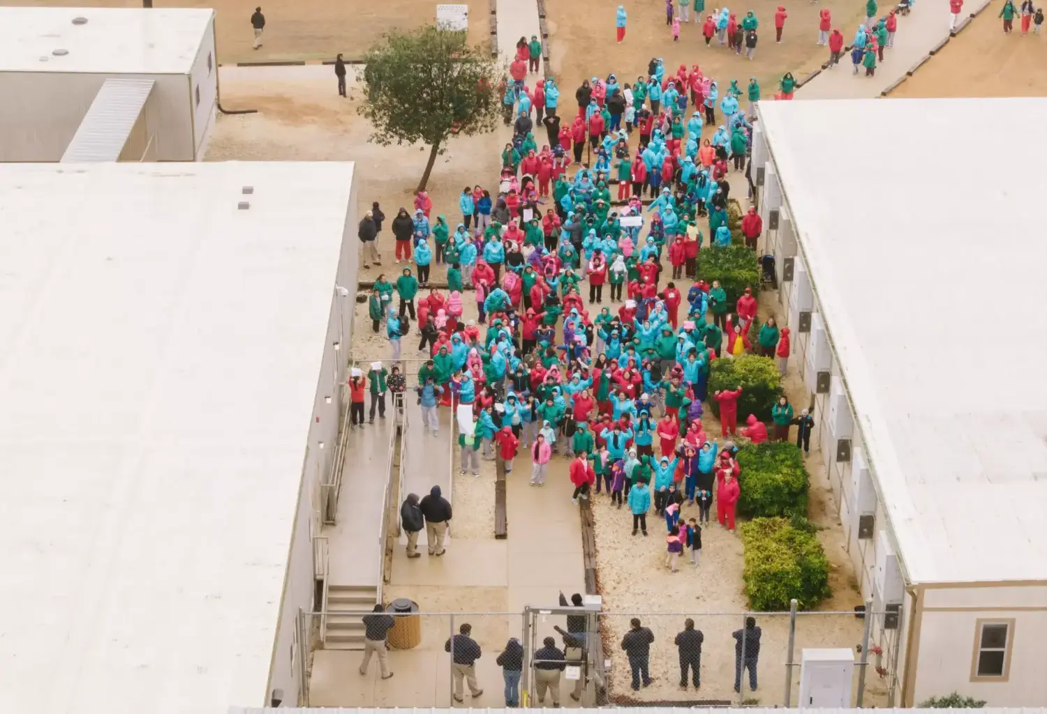 File - Immigrants seeking asylum walk through the ICE South Texas Family Residential Center in Dilley, Texas.