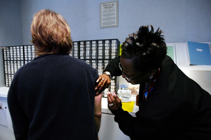 Bonnie Grossfeld (left) receives an allergy shot from medical assistant Dee Dee Mitchell at...