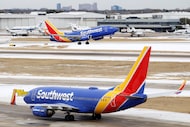 A Southwest Airlines jet takes off as another taxis to the runway at Dallas Love Field,...