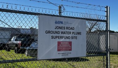 A sign posted behind a shopping center at 11600 Jones Road warns community members about an identified groundwater plume. (Sarah Brager/Community Impact)