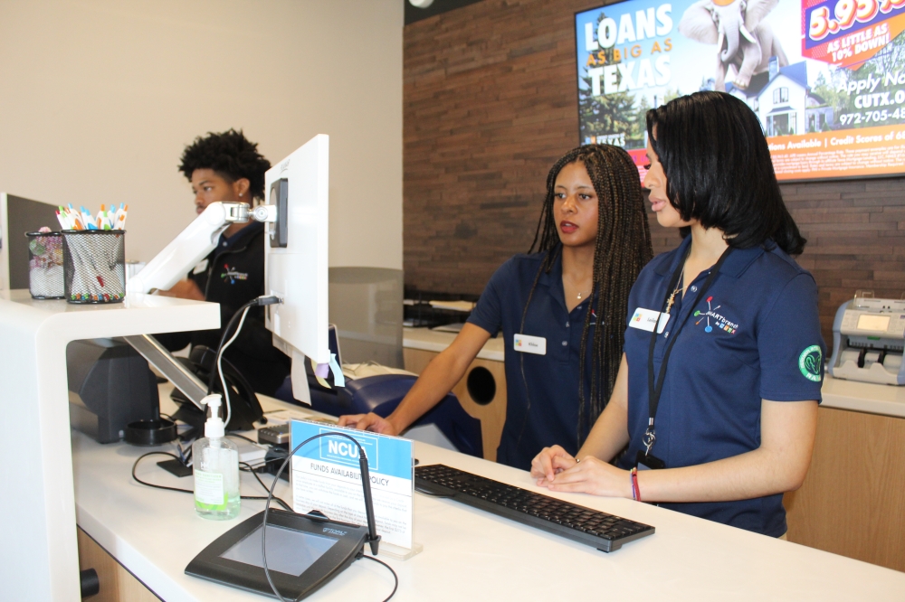 From left, Richardson ISD students Ja’Vone Daniels, Khloe Chaney and Leilani Freeman work at the Credit Union of Texas Smart branch inside Berkner High School. (Michael Crouchley/Community Impact)