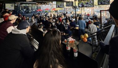 People sitting down watching football at a bar