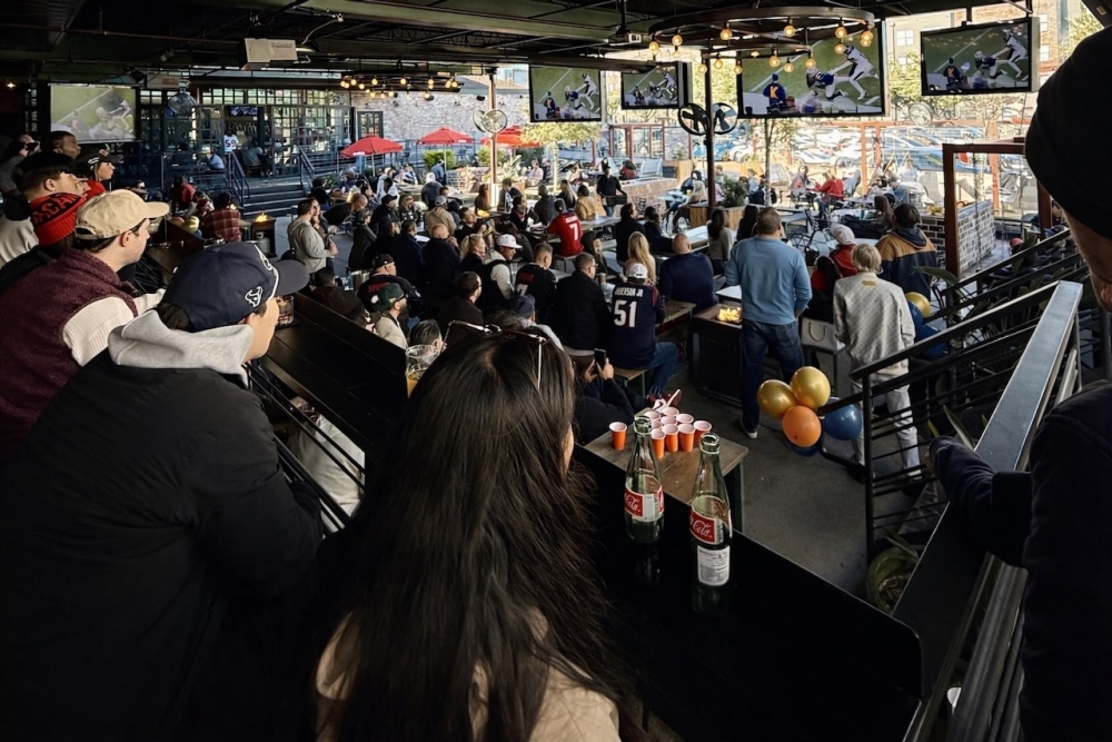 People sitting down watching football at a bar