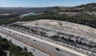excavators digging up rock by road