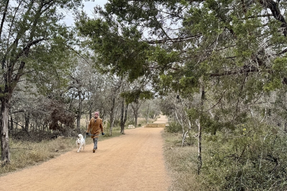 A man walks his dog in Phil Hardberger Park