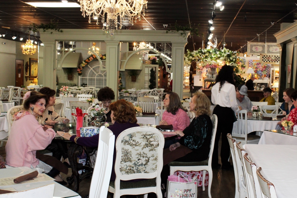 A table of women having conversations in a restaurant.