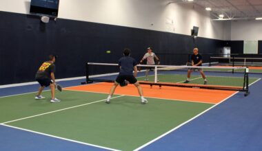 Four men playing pickleball on an indoor court.