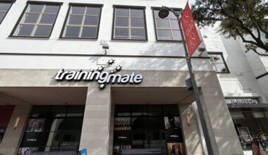 Exterior of a strip center with Training Mate signage over one space.