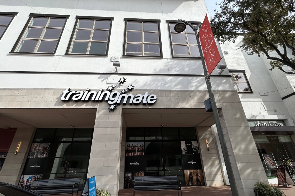 Exterior of a strip center with Training Mate signage over one space.